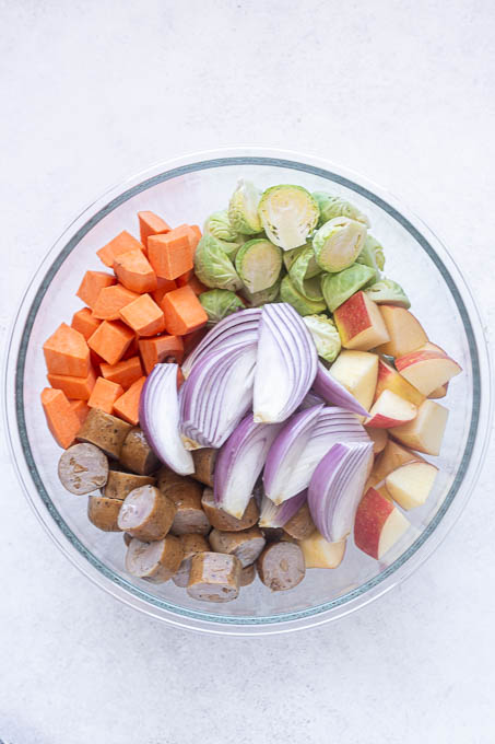 chicken apple sausage sheet pan dinner ingredients in bowl.