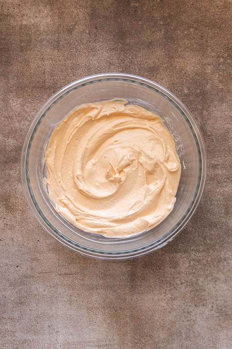Wet ingredients for buffalo chicken dip combined in a bowl.