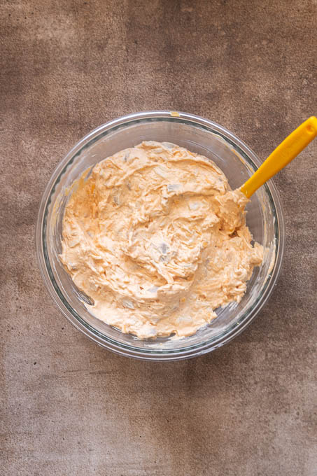 Buffalo chicken dip with chicken and cheese in a bowl.