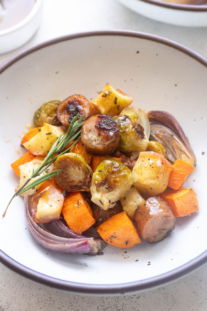 Bowl of roasted chicken apple sausage with sweet potatoes and fall veggies.